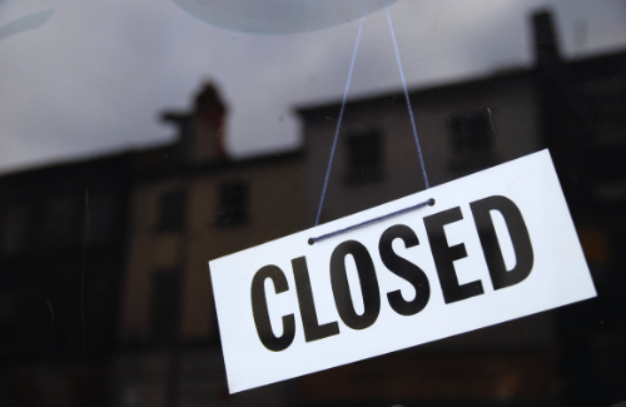 White sign Sign in window with black font that reads: Closed